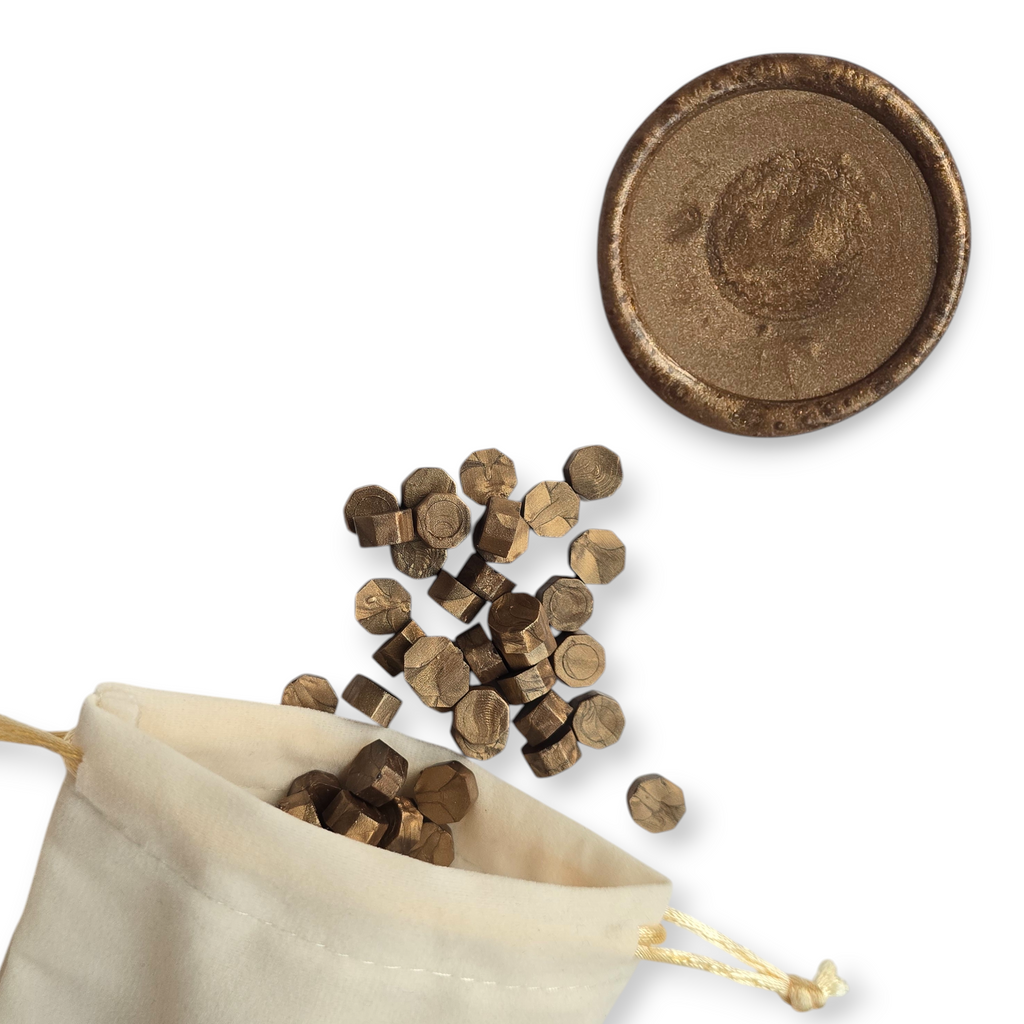 Bronze wax beads spilling out of a beige drawstring bag onto a white background. In the top right corner is a blank wax seal in the showcasing the bronze colour option.