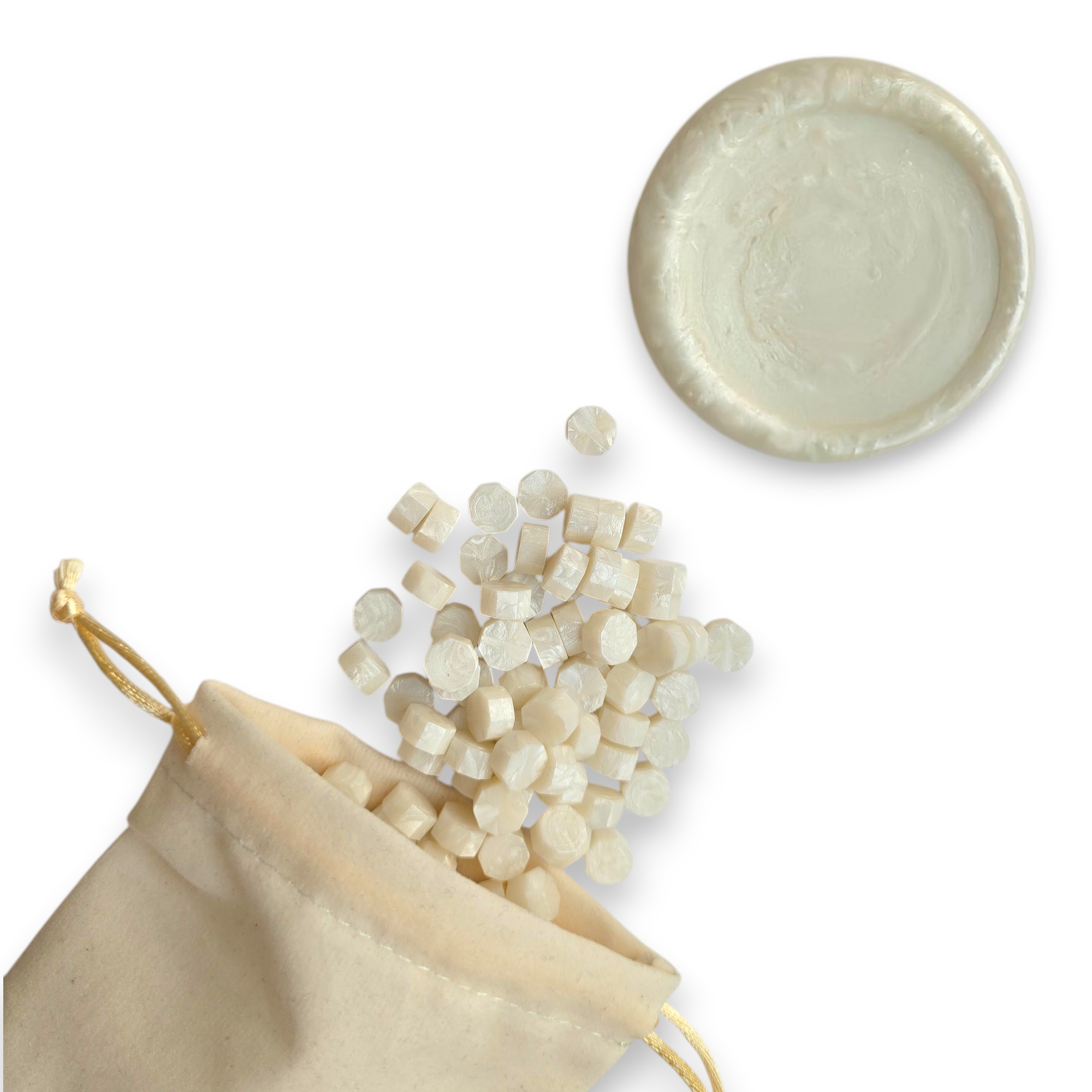 Pearl wax beads spilling out of a beige drawstring bag onto a white background. In the top right corner is a blank wax seal in the showcasing the pearl colour option.